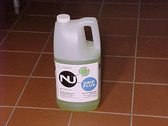 Nu-Grip Plus container on tiled floor, representing the first patented biotech degreaser launched by InnuScience in 2000.