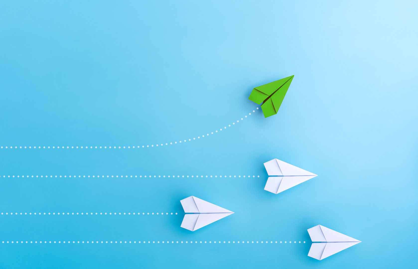 Why Partner with InnuScience: Leading biotech cleaning innovation for private label success. Green paper airplane leading white airplanes, symbolizing innovation and leadership in biotech cleaning private label solutions.